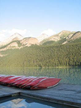 canoes by a lake and mountains