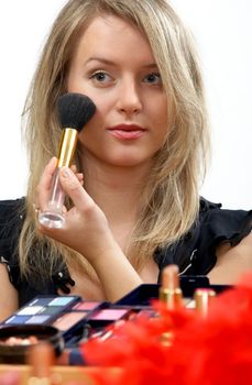 young beautiful woman is making up for itself in front of a mirror