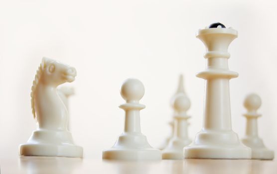 white set of chess on the board over light background