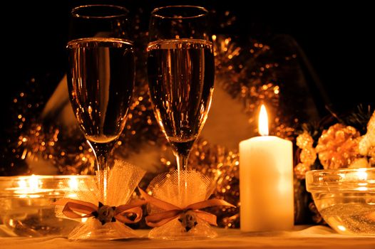 two glasses of champagne, candles with christmas decorations