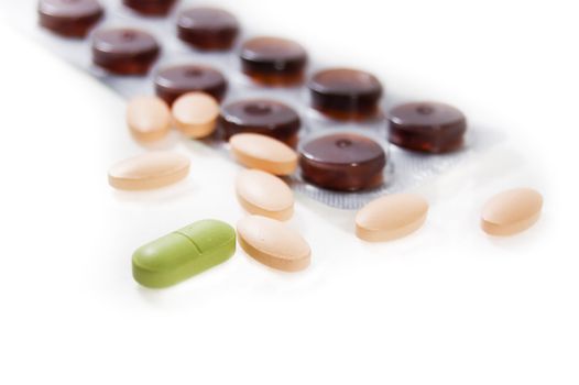 some colorful pills with bottle on a white background