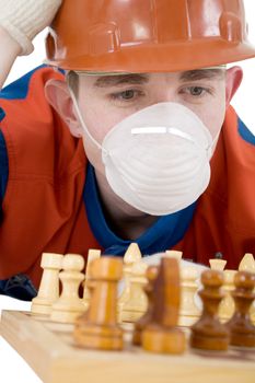 Man in worker to cloth and respirator play of chess