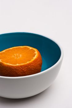 tangerine in blue and white bowl on white background