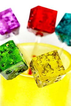 bounch of colorfull translucent dice shaped lollipops backlit on white background