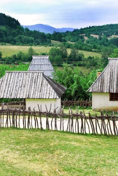 Ethnic Serbia, wooden house behind fence over rural landscape
