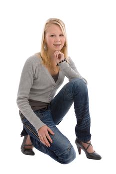 Cute blond teenage girl kneeling on white background