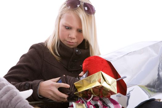 Young teenage girl surrounded by shopping bags looking shocked into her wallet