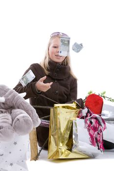 Young blond teenage girl sitting on the floor with money raining down