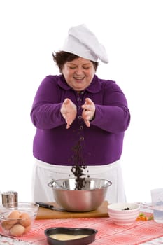 Happy chef throwing a handfull of raisins in the mixing bowl