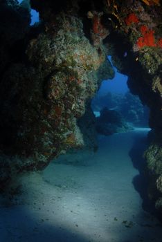 A coral reef arch formation making a swimthrough cave on the floor of the ocean 