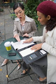 Two business women having a casual meeting in the city.  Shallow depth of field.