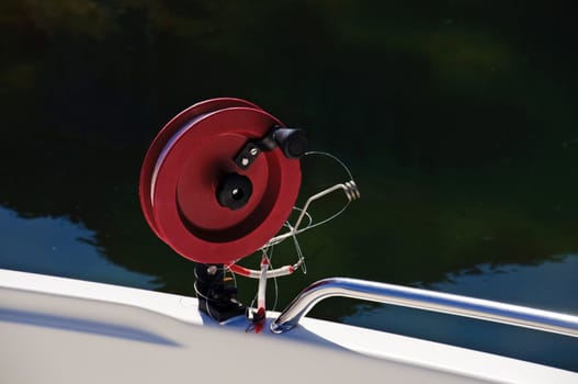 A red fishing reel on a boat.