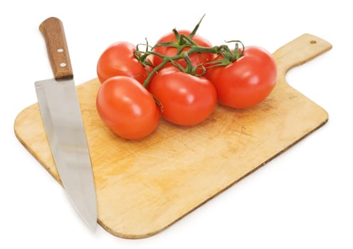 Ripe red tomatoes and kitchen knife on a chopping board