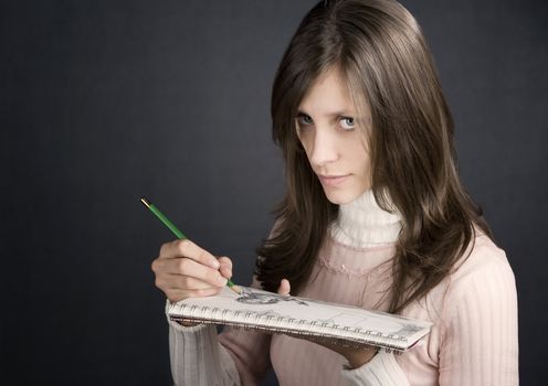 Pretty female artist with pencil and drawing pad