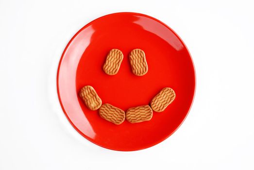Red plate with cake eyes and mouth isolated over white