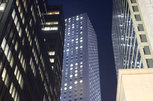 Hongkong city center by night. Modern skyscrapers, office buildings surrounding street in Central district.
