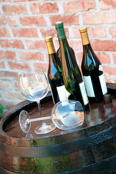 Wine bottles and glasses on wooden barrel