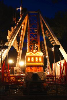 illuminated Construction of carousel in evening park