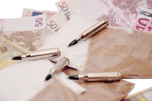 a stash of drugs bullets and money showing a dangerous cost to life against a white background