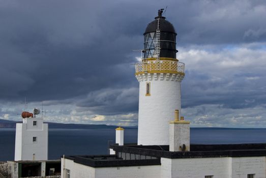 Lighthouse in northern Scotland with Orkney in the background