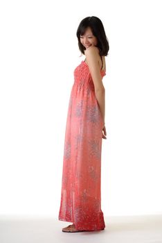 Pleasure woman of Asian in pink dress standing against white background.