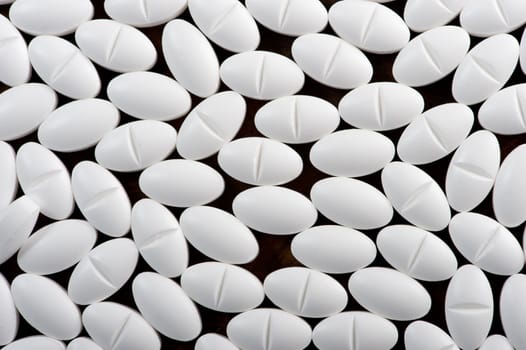 White pills seen on dark background