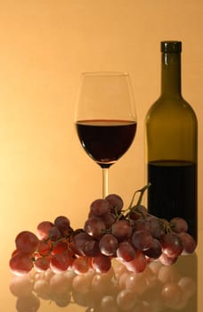 Still-life with grapes near goblet and bottle of red wine