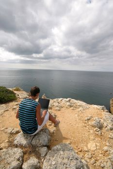 man working with laptop on the coast