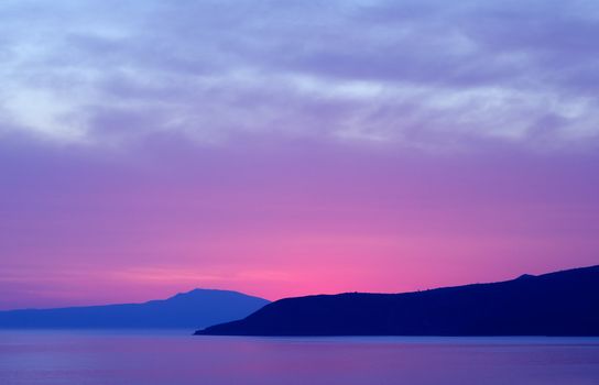 Serene scenery showing far away land under spectacular dusky colours