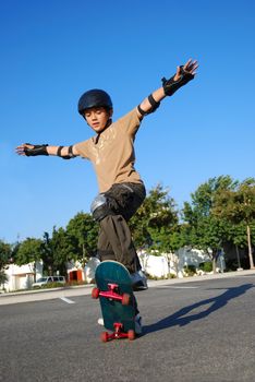 Boy doing stunts on a skateboard in afternoon sun with blue sky in the background