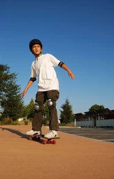 Boy riding a skateboard in afternoon sun