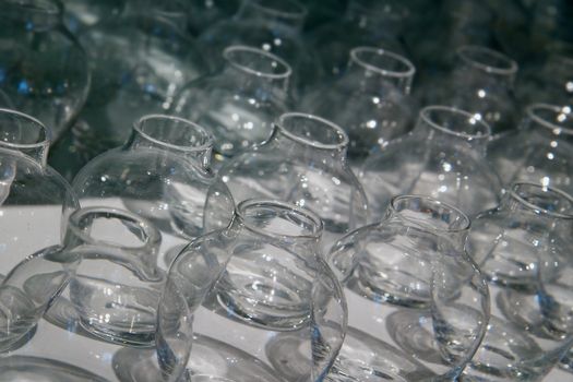 Rows of empty flower vase shaped glass containers