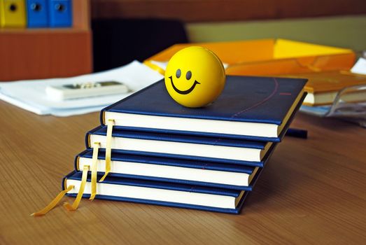 new blue organizers and yellow smiley ball on office desk