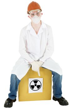 Man in doctor's smock and respirator sits on carton box