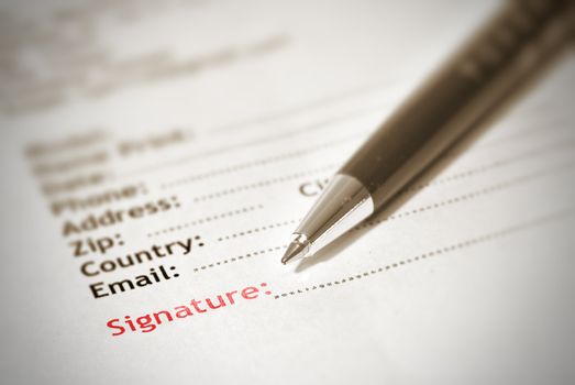 Signature on paper with pen in brown color.