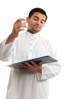 An ethnic middle eastern mixed race business man wearing a white traditional woven robe and holding a clipboard folder and pen.   Man's right hand shows motion.