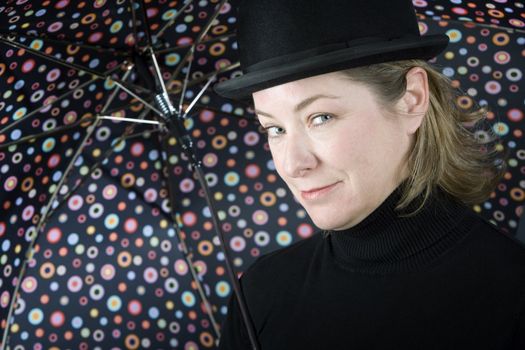 Woman in bowler hat with spotted umbrella