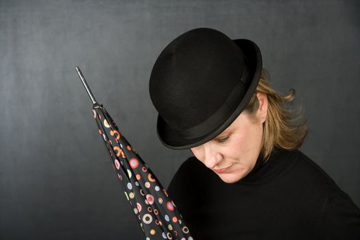 Woman in bowler hat with spotted umbrella