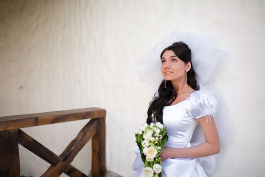 bride by the white wall looking up