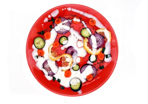 red plate with cut vegetables isolated over white