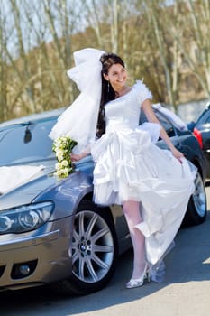 happy bride by the car