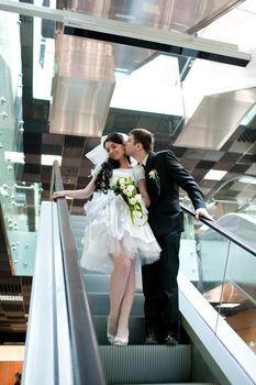 bride and groom in metro kissing