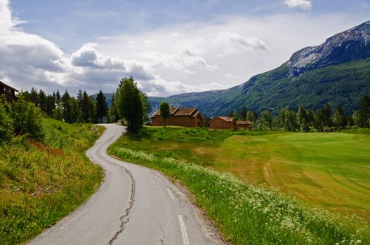 A country road in the mountains passing a golf course