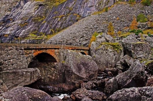 A stone bridge in a rocky valley. Crossing a river, autumn. Maaboe (Måbø) valley in Western Norway. 