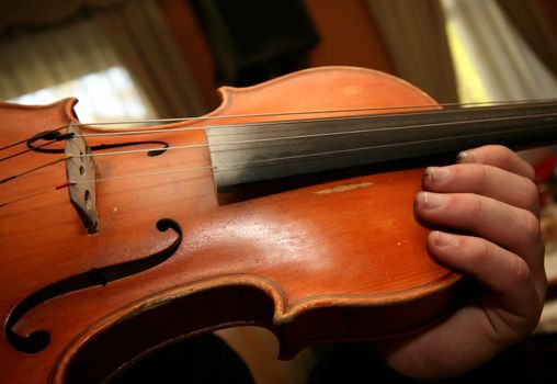 The person plays on a violin at restaurant