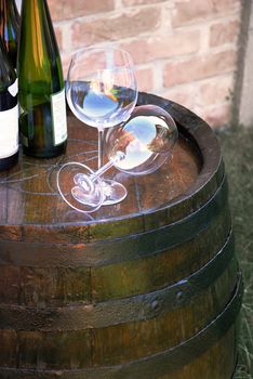 glasses and bottles of wine over wooden barrel