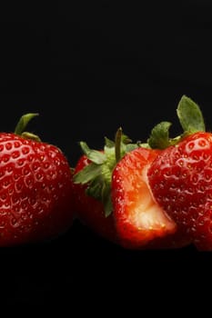fresh vivid colored strawberry over black background