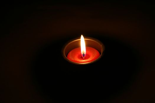 A solitary candle in the middle of darkness