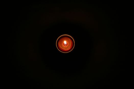 A solitary candle in the middle of darkness