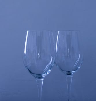 A couple of empty glasses in tunsgtene blue light